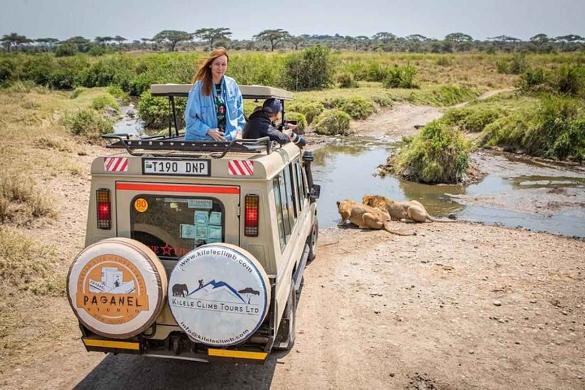 žena jedoucí na střeše safari vozidla