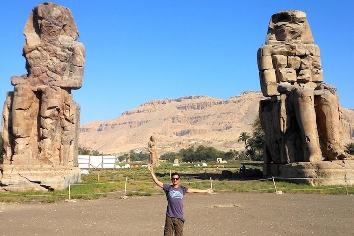 seorang lelaki berdiri di hadapan monumen batu
