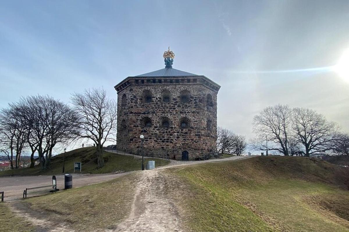 a tower on top of a hill with a dirt road