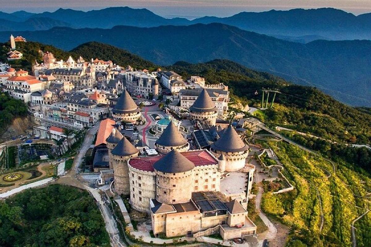 Una vista aérea de un castillo con montañas al fondo.