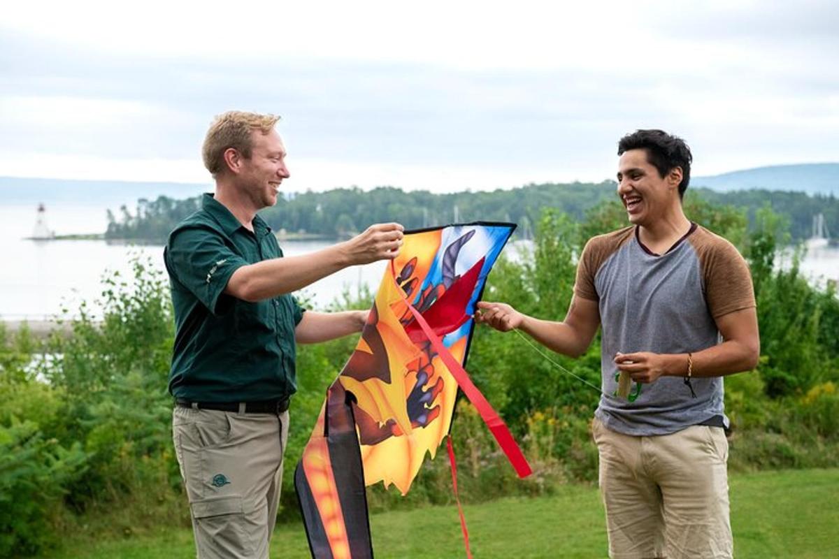 two men are holding a kite in a field
