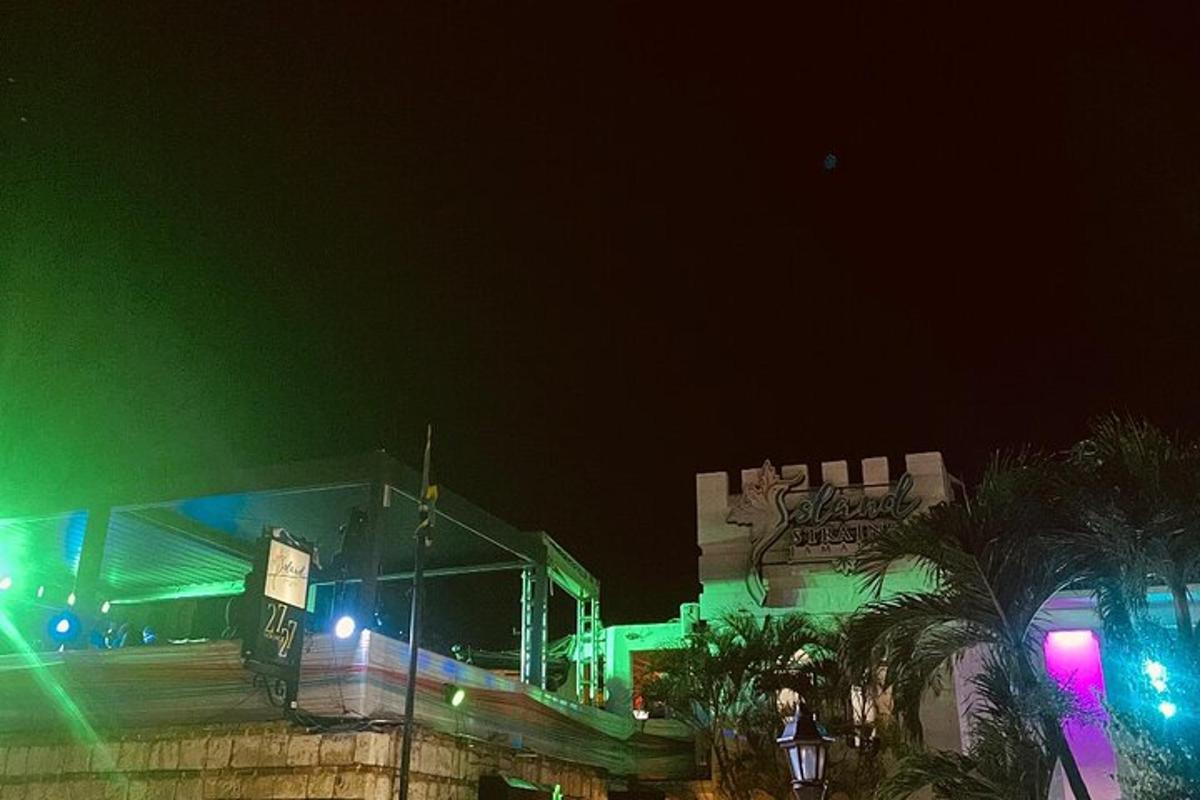 Un edificio con luces verdes y moradas por la noche.
