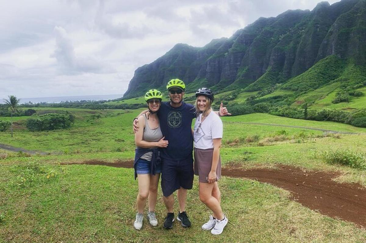 Tres personas con cascos posando para una foto en una montaña