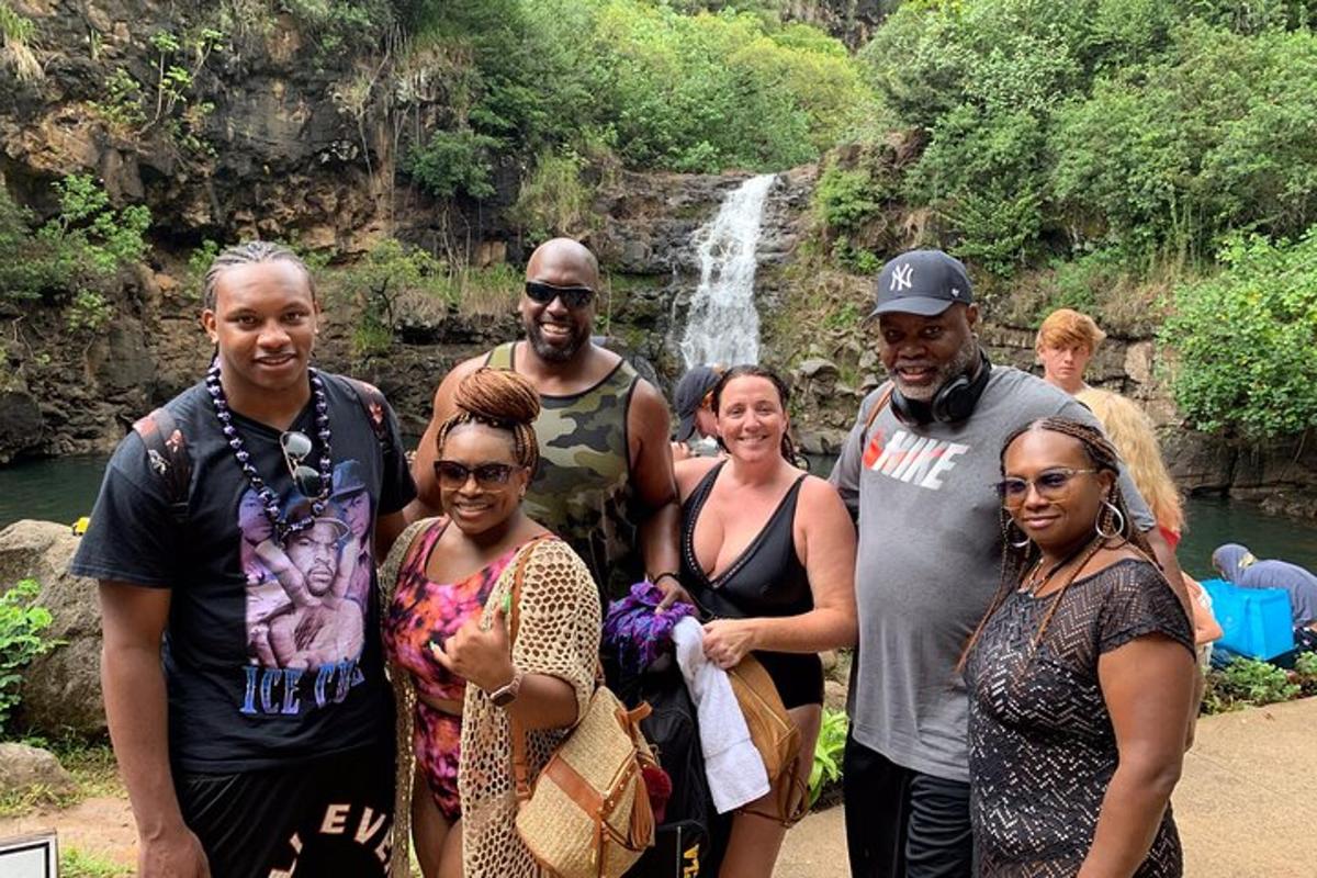 Un grupo de personas de pie frente a una cascada.