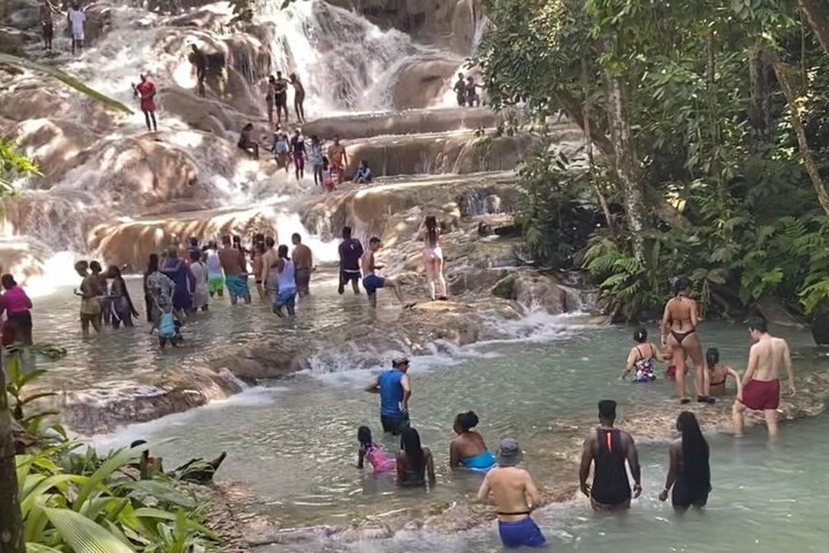 sekumpulan orang di dalam air di air terjun