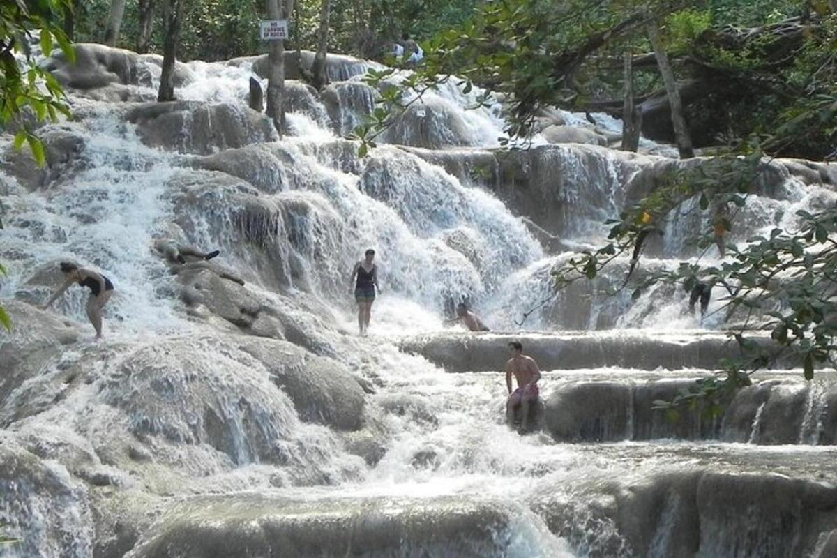 sekumpulan orang berdiri di dalam air terjun