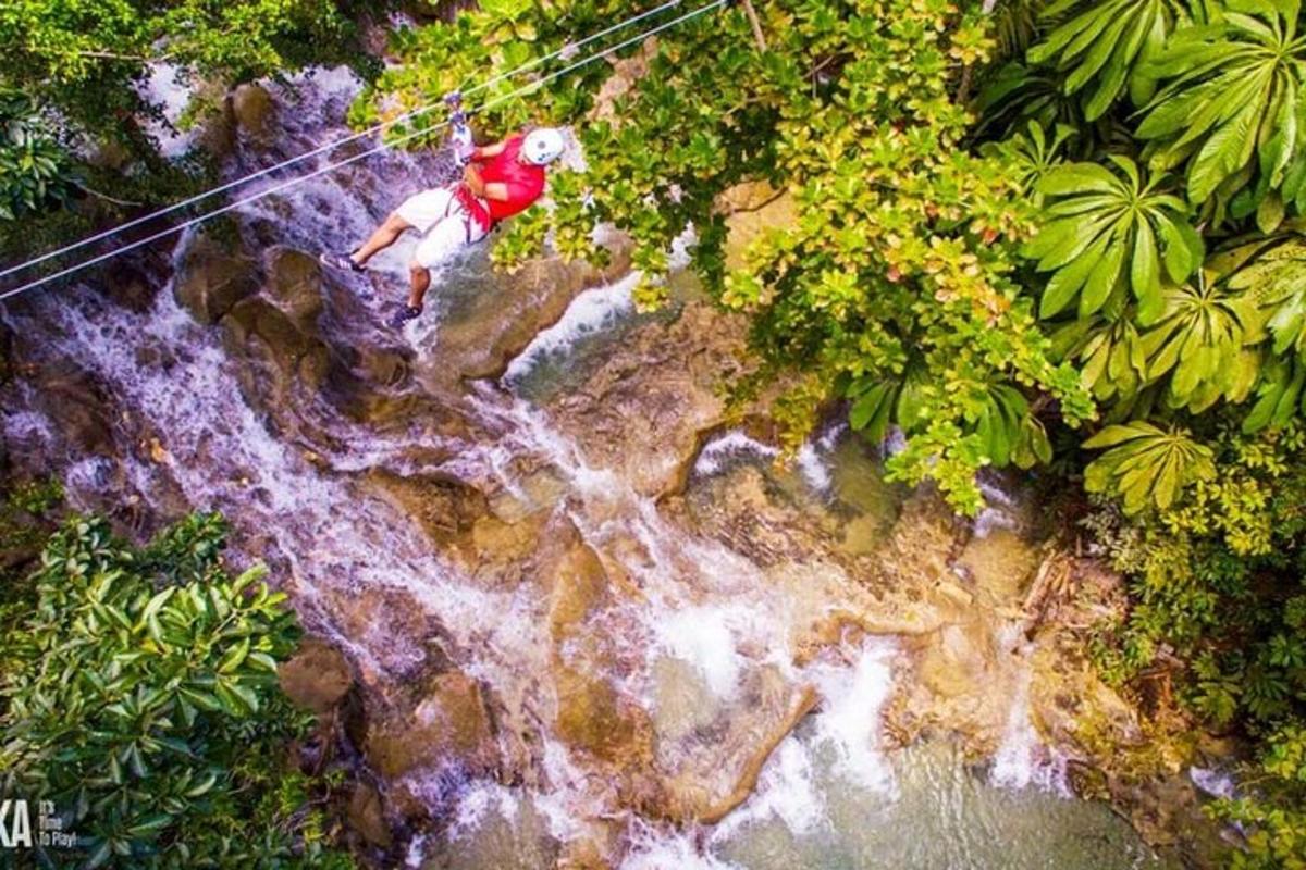 muž jedoucí na zipline přes vodopád