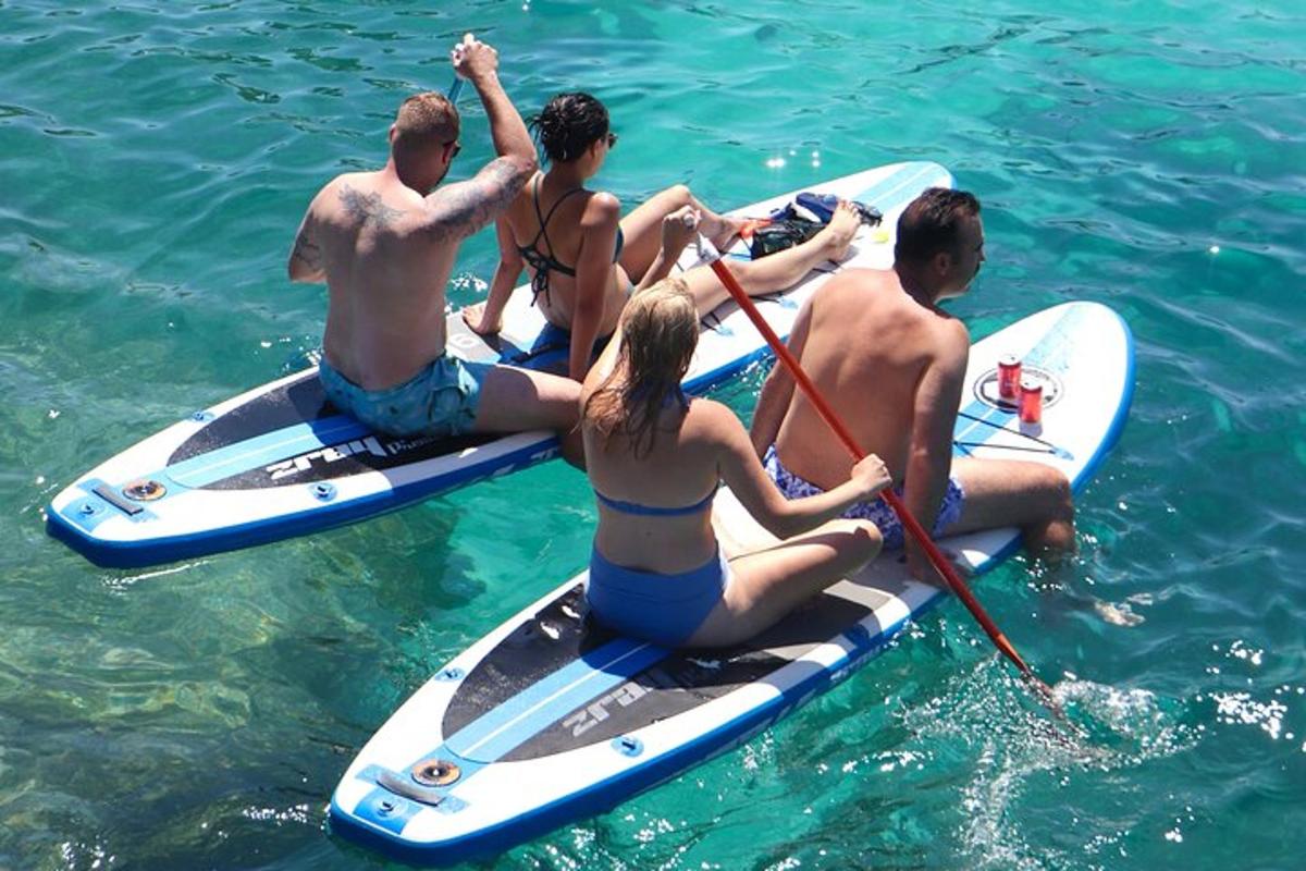 un grup de persones assegudes en taules de surf a l'aigua