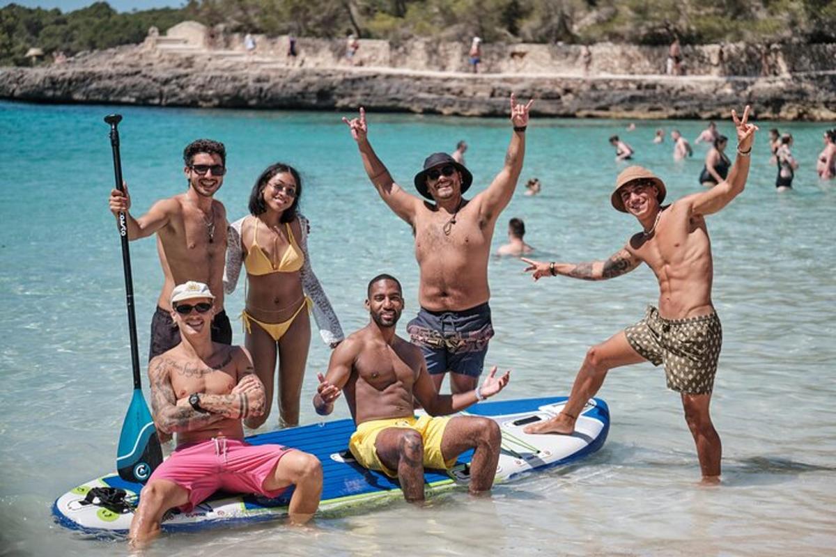 un grup de persones dempeus a l'aigua a la platja