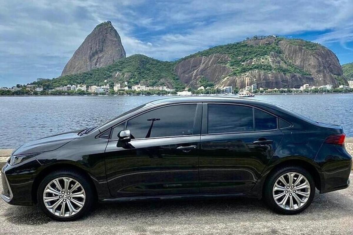 Un coche negro estacionado junto a un cuerpo de agua