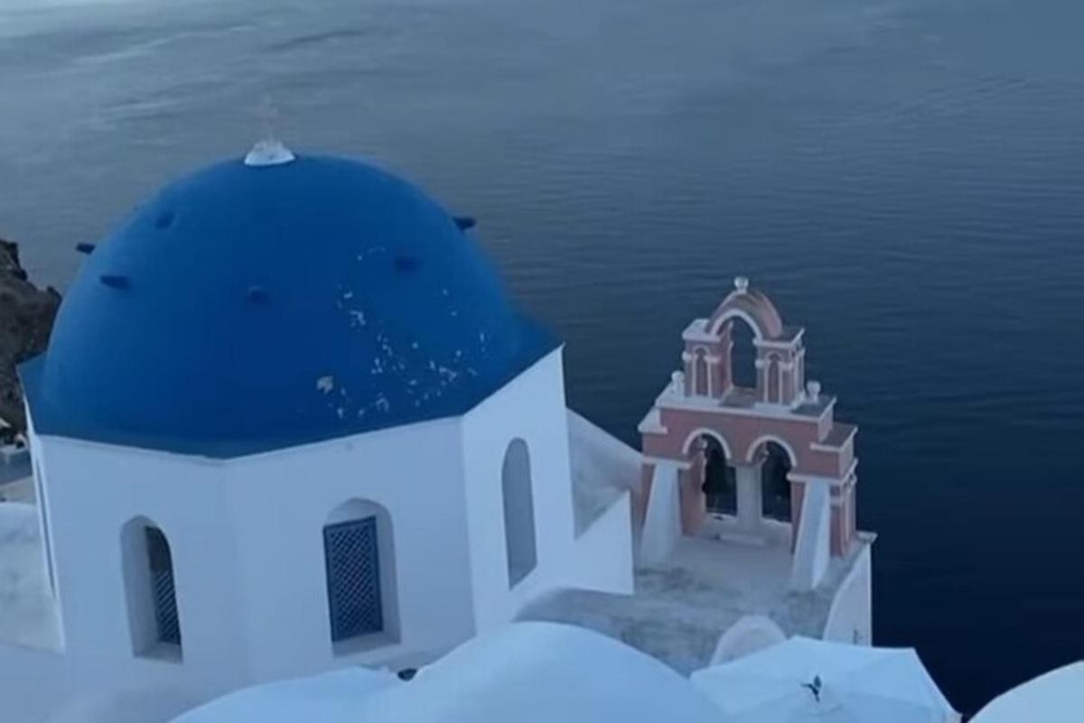 un petit edifici amb una cúpula blava sobre l'aigua