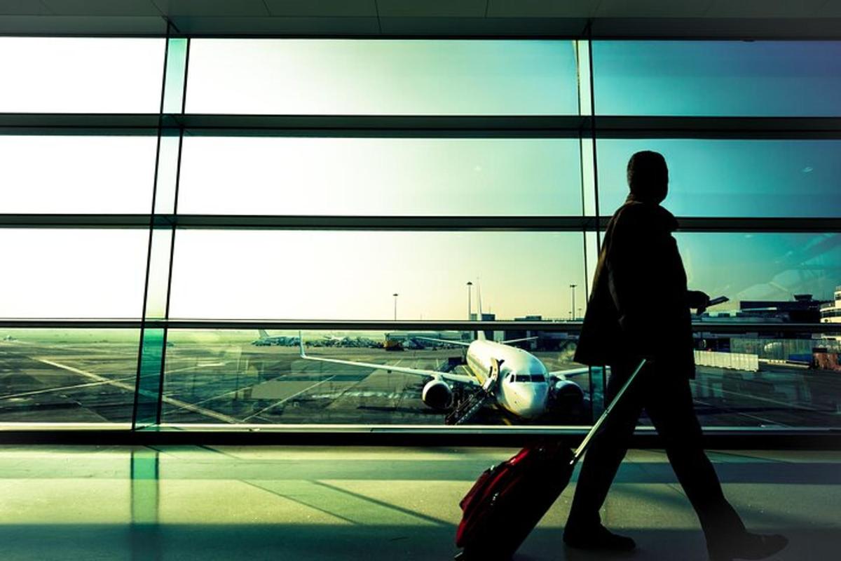 una persona caminant per un aeroport mirant un avió