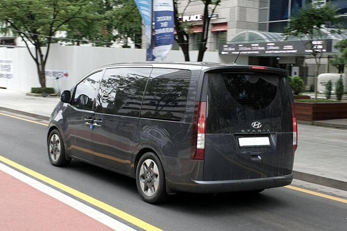 Crni kombi vozi se gradskom ulicom