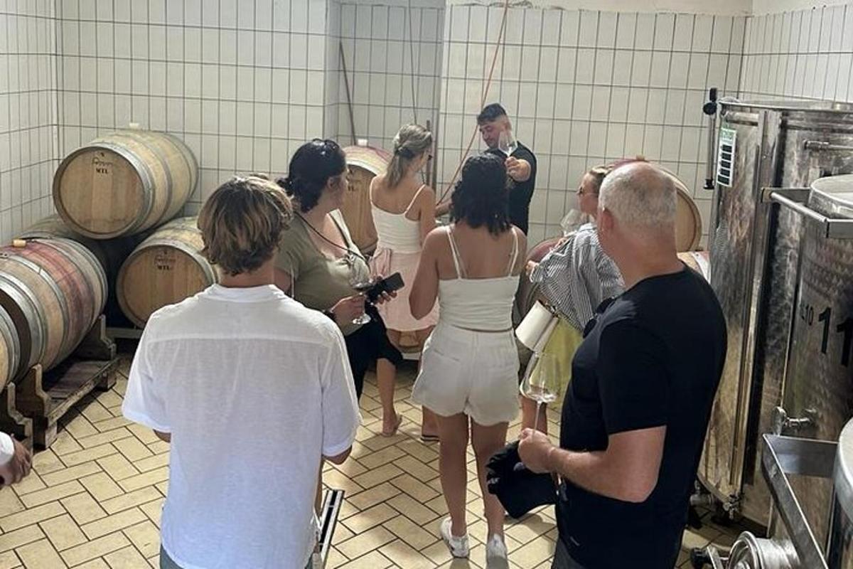 un gruppo di persone in piedi in una cantina vinicola
