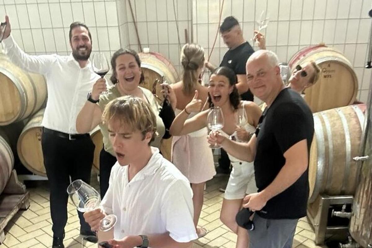 un gruppo di persone che bevono vino in una cantina