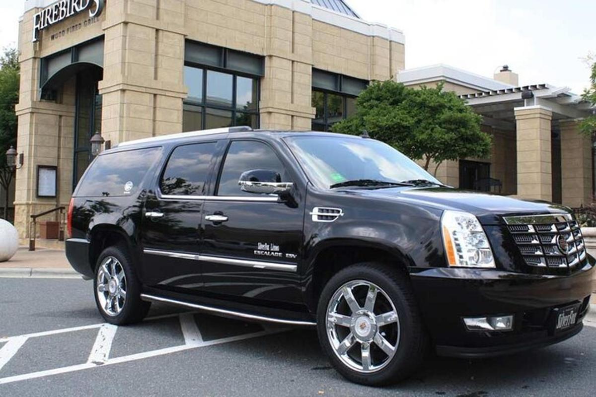 a black truck parked in a parking lot in front of a building
