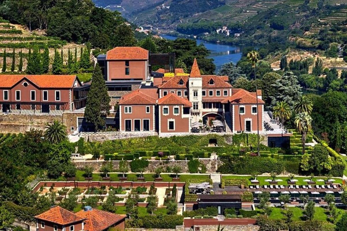 una grande casa su una collina vicino a un lago