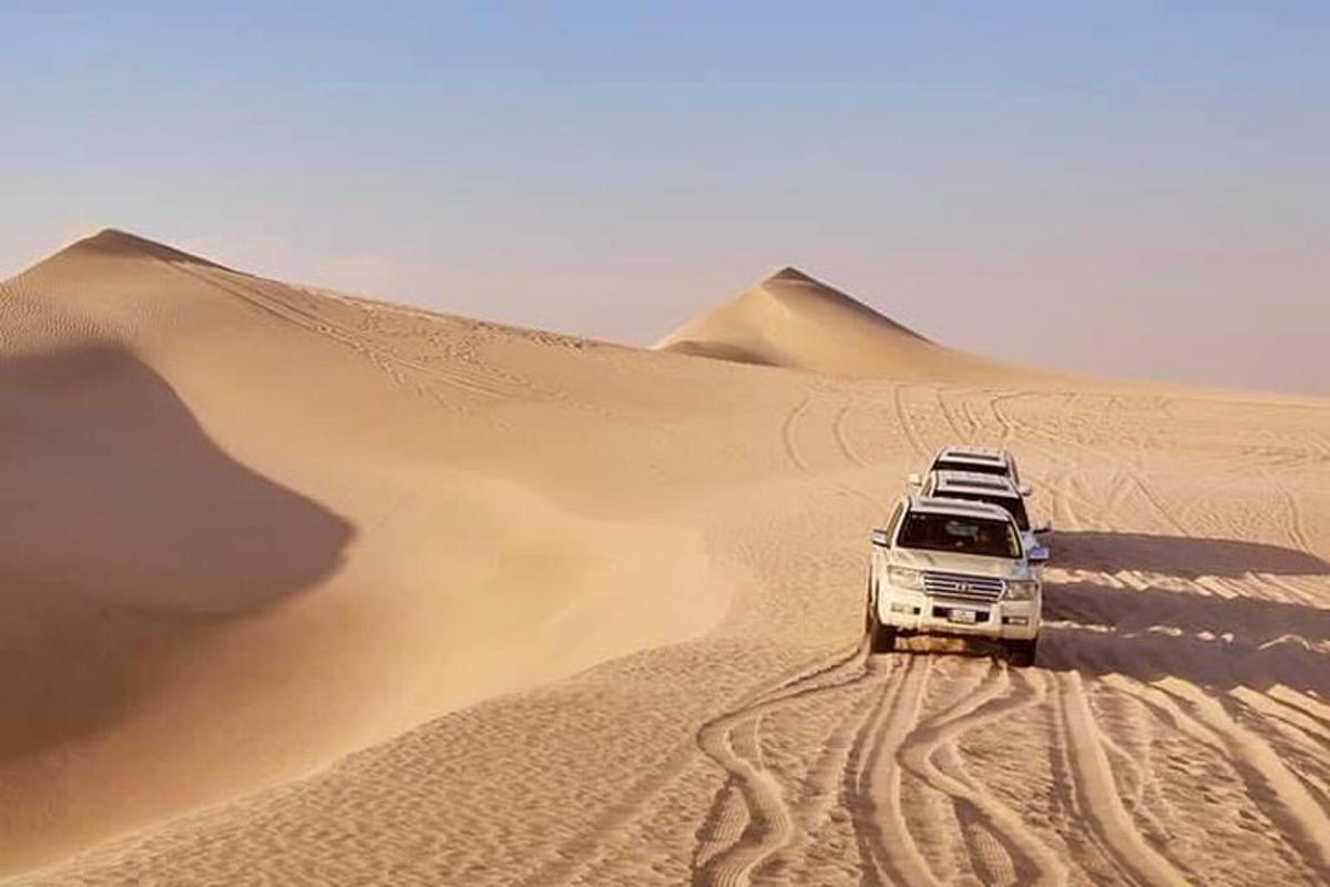 a truck driving in the sand in the desert