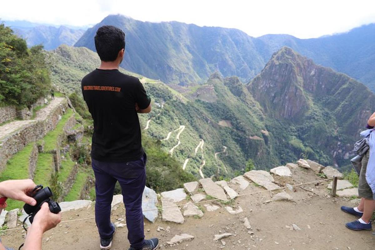 Un hombre tomando una fotografía de una vista de la montaña.