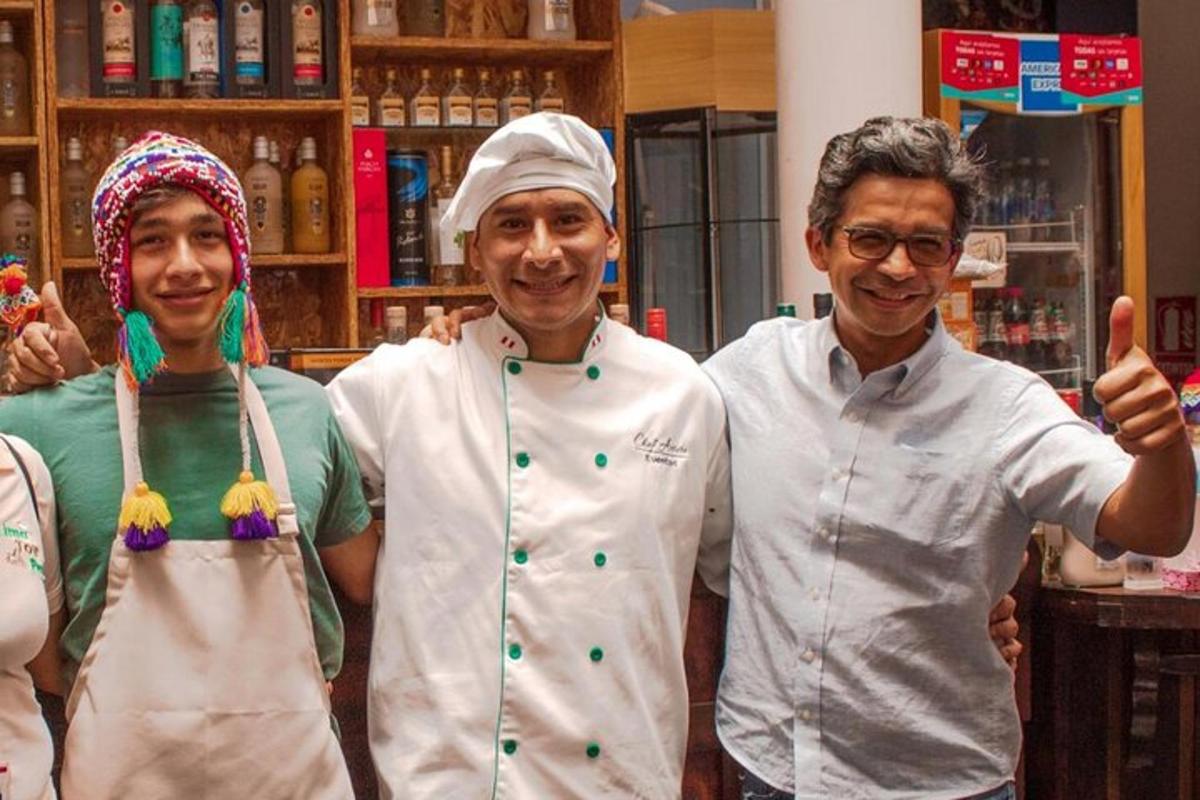 Un grupo de tres chefs de pie en una cocina.