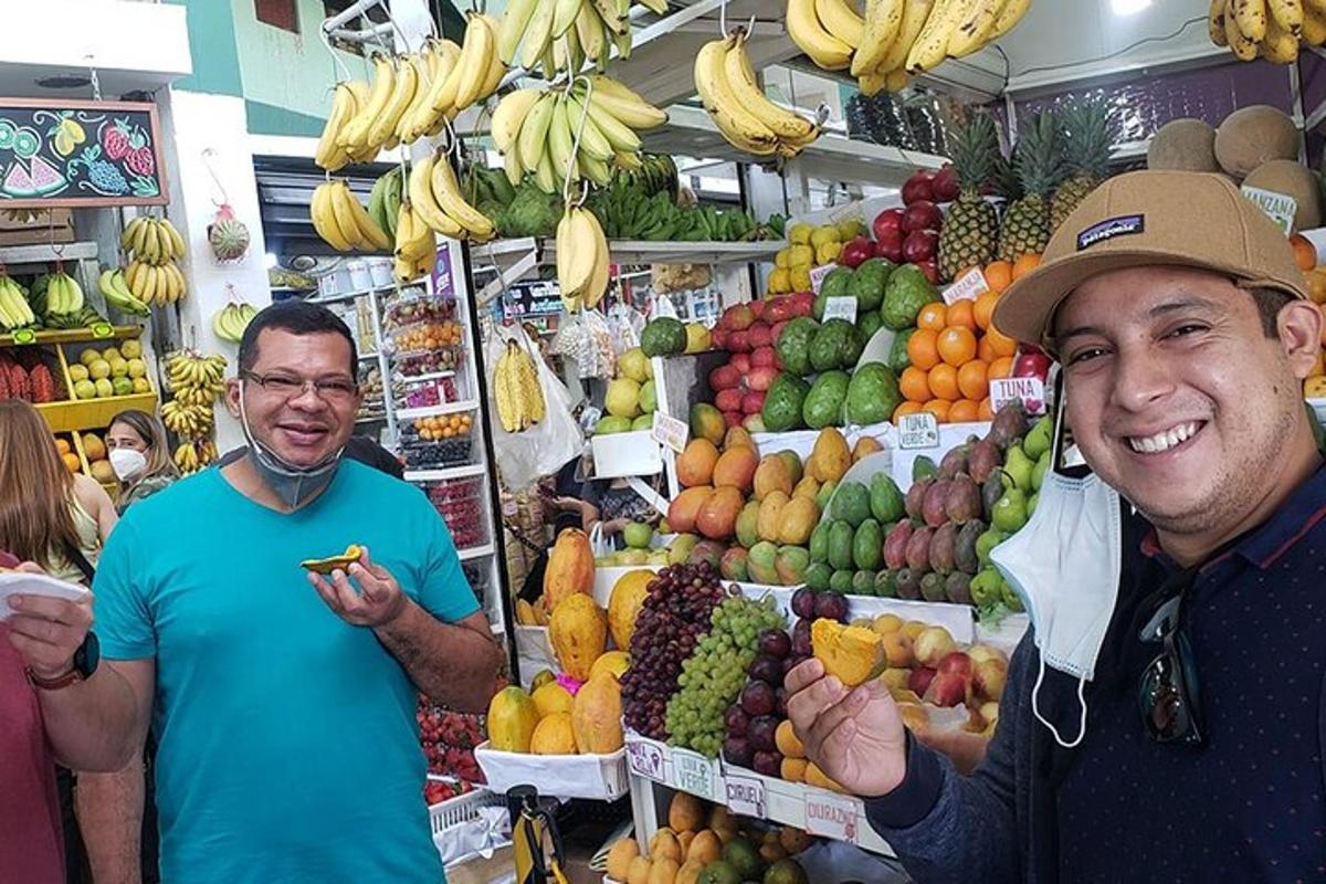 due uomini in piedi in un mercato con frutta e verdura