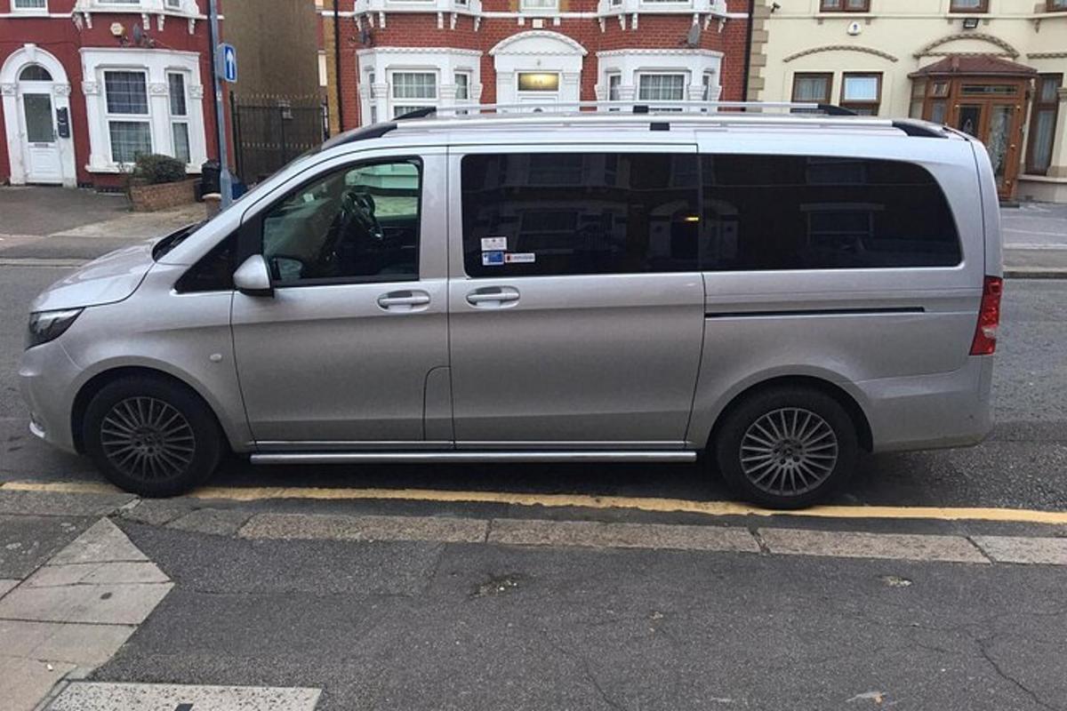 Una camioneta plateada estacionada al costado de una calle