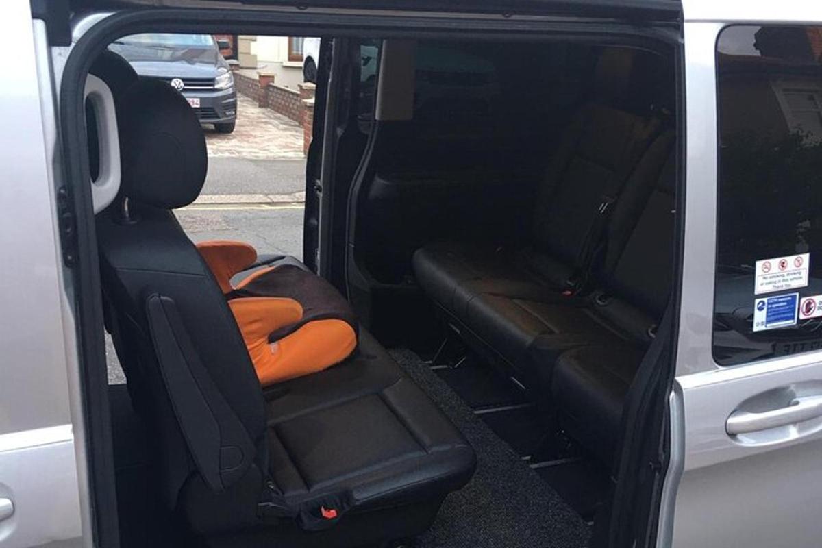 Un asiento trasero de una camioneta con una puerta abierta