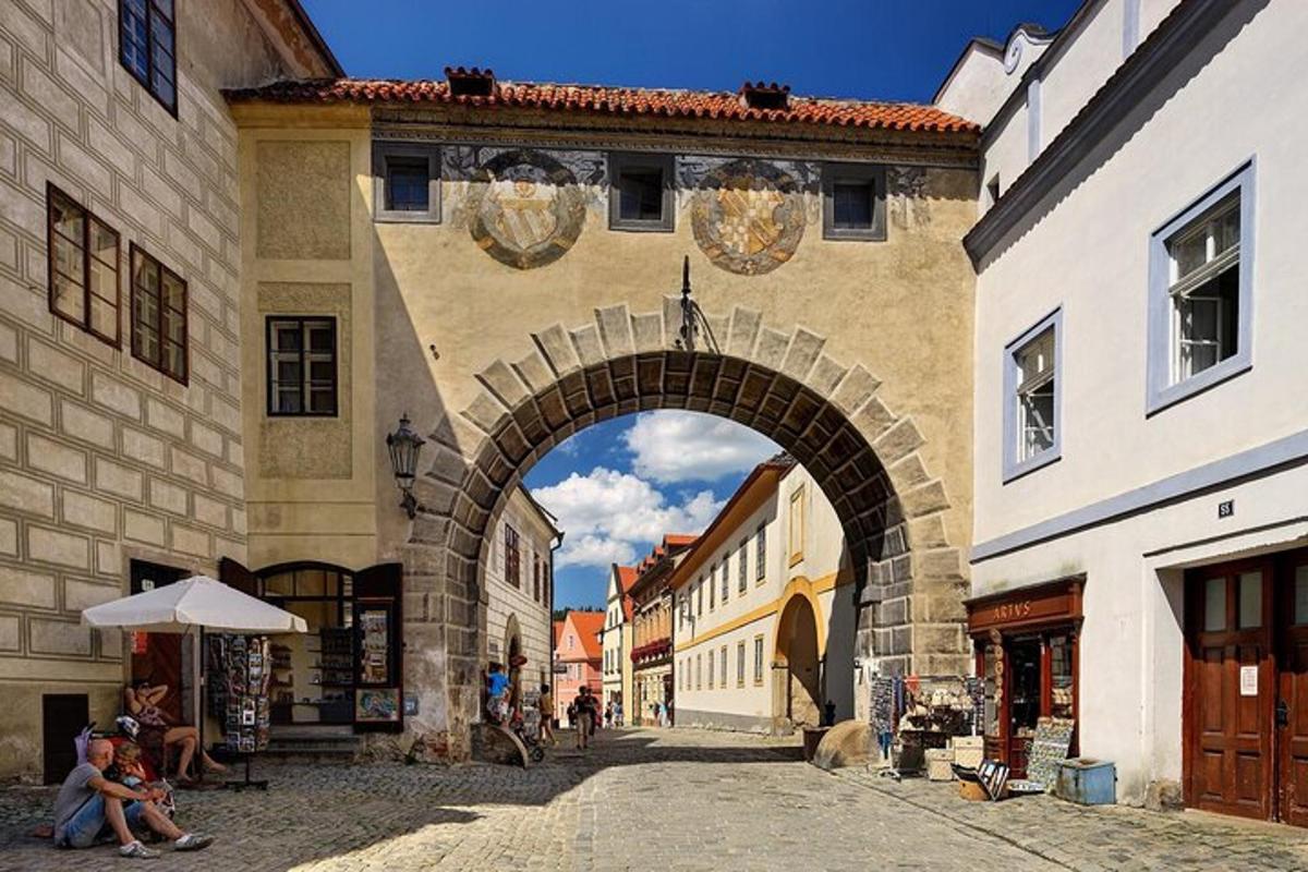 un arco in un edificio con persone sedute sotto un ombrello