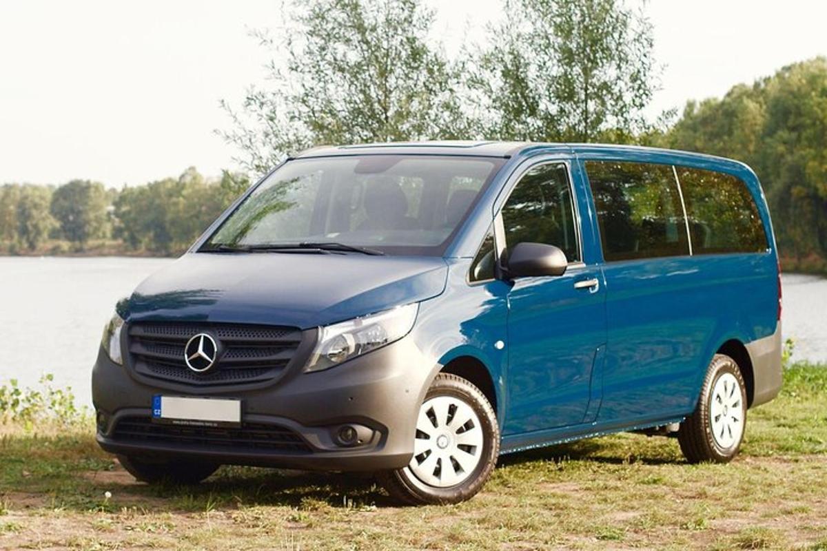 un furgone blu parcheggiato in un campo vicino a un lago