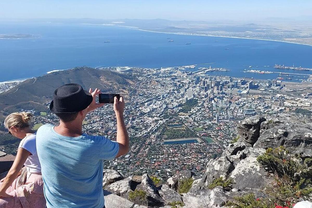 en man som tar en bild av en stad från ett berg