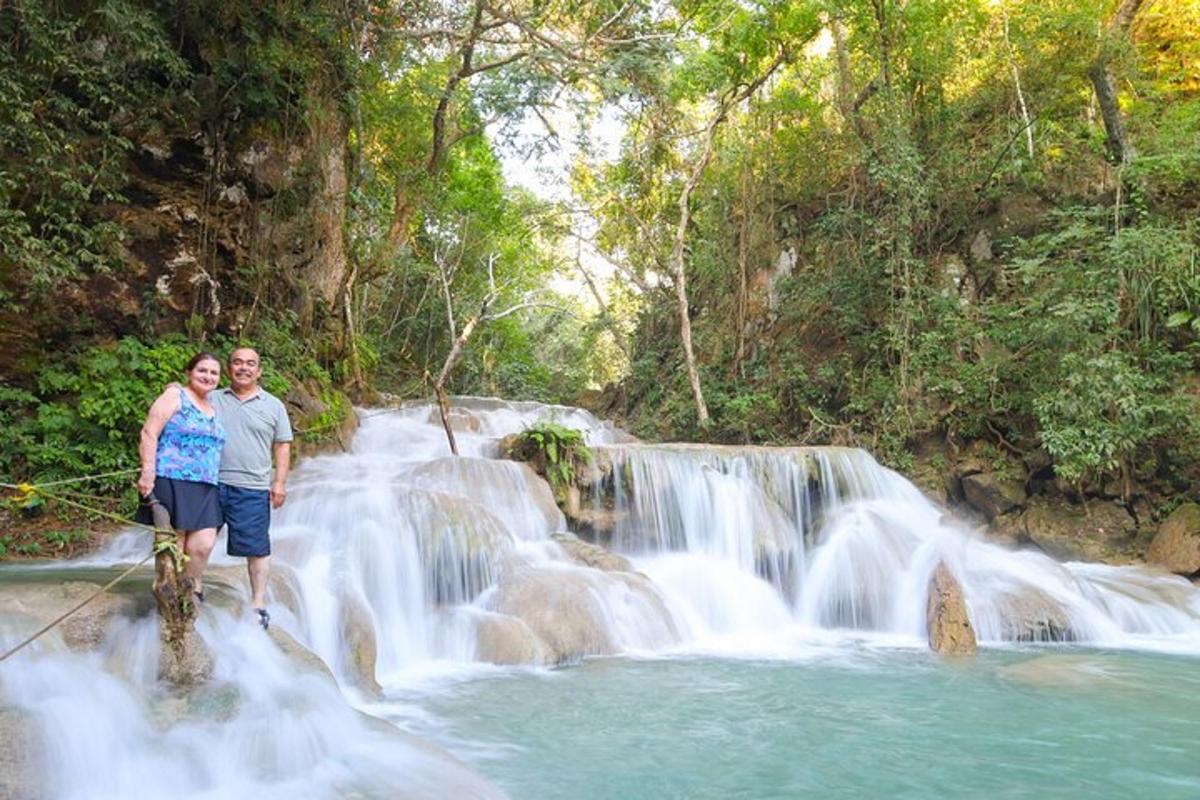 un uomo e una donna in piedi davanti a una cascata