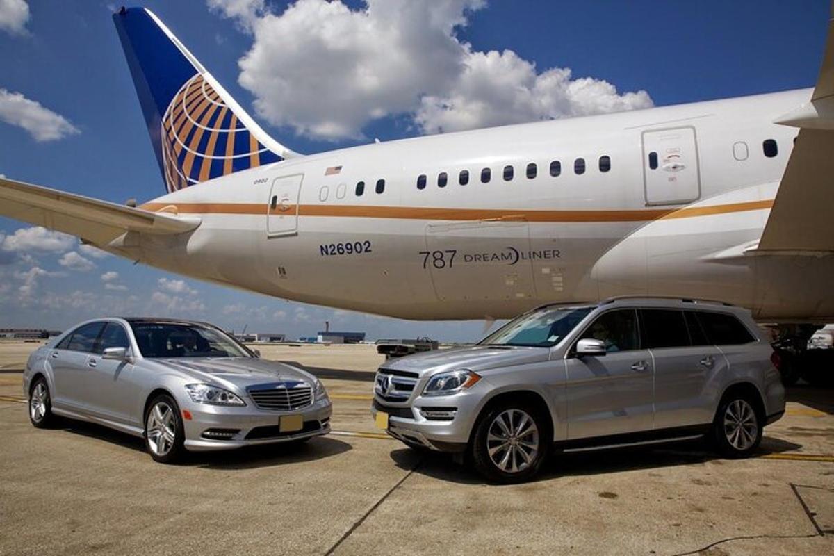 zwei Autos sind neben einem Flugzeug geparkt