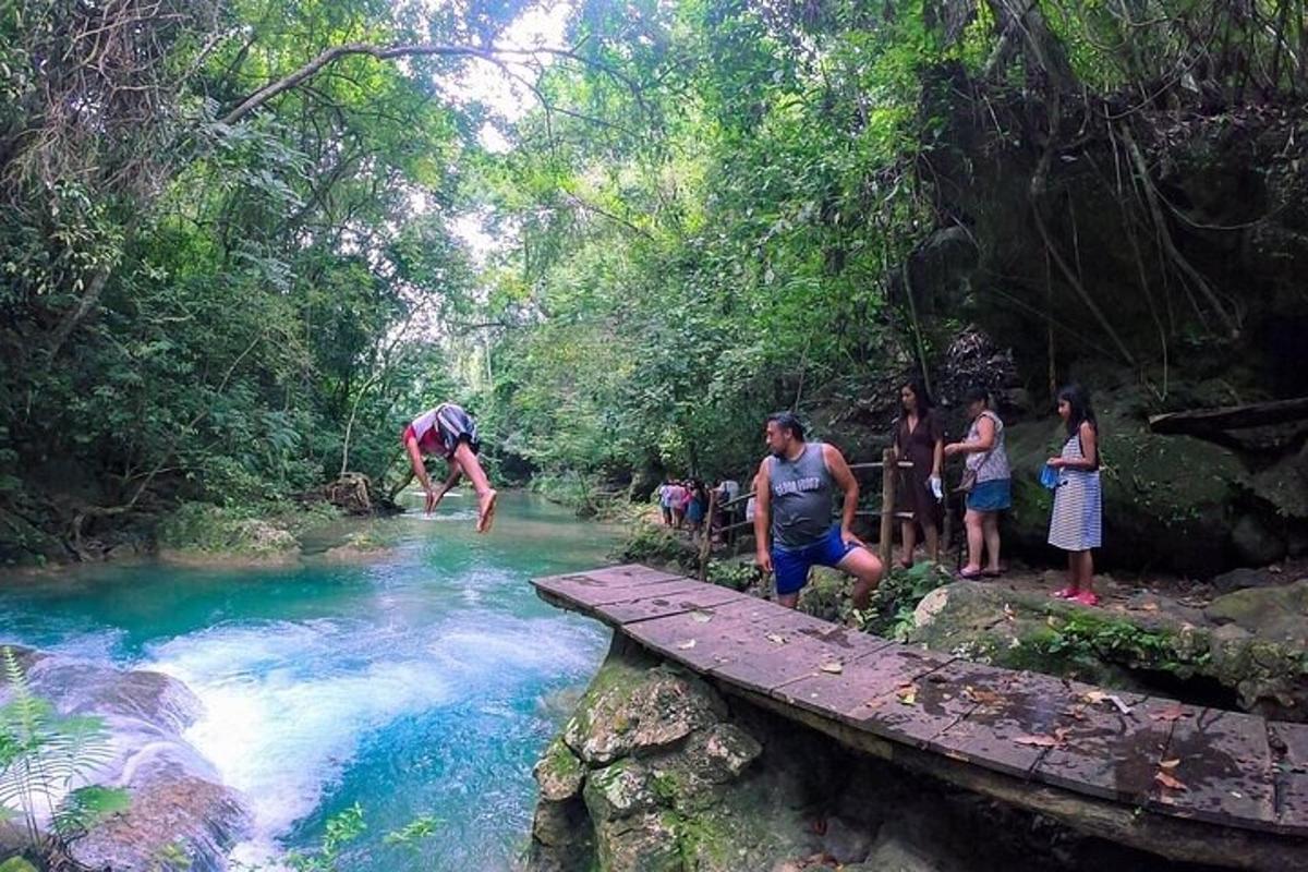 un gruppo di persone in piedi su un ponte di legno sopra un fiume