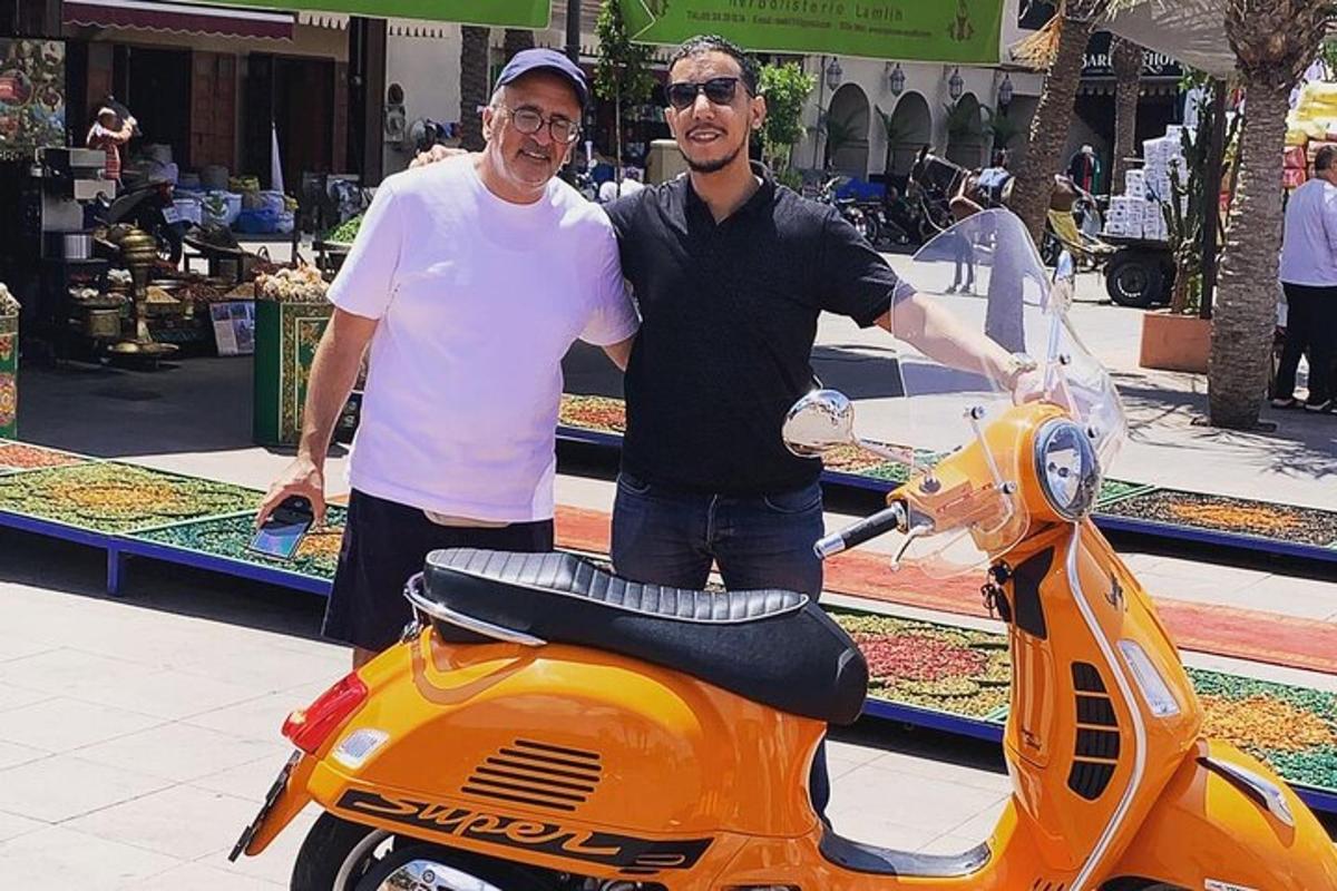 to menn står ved siden av en scooter