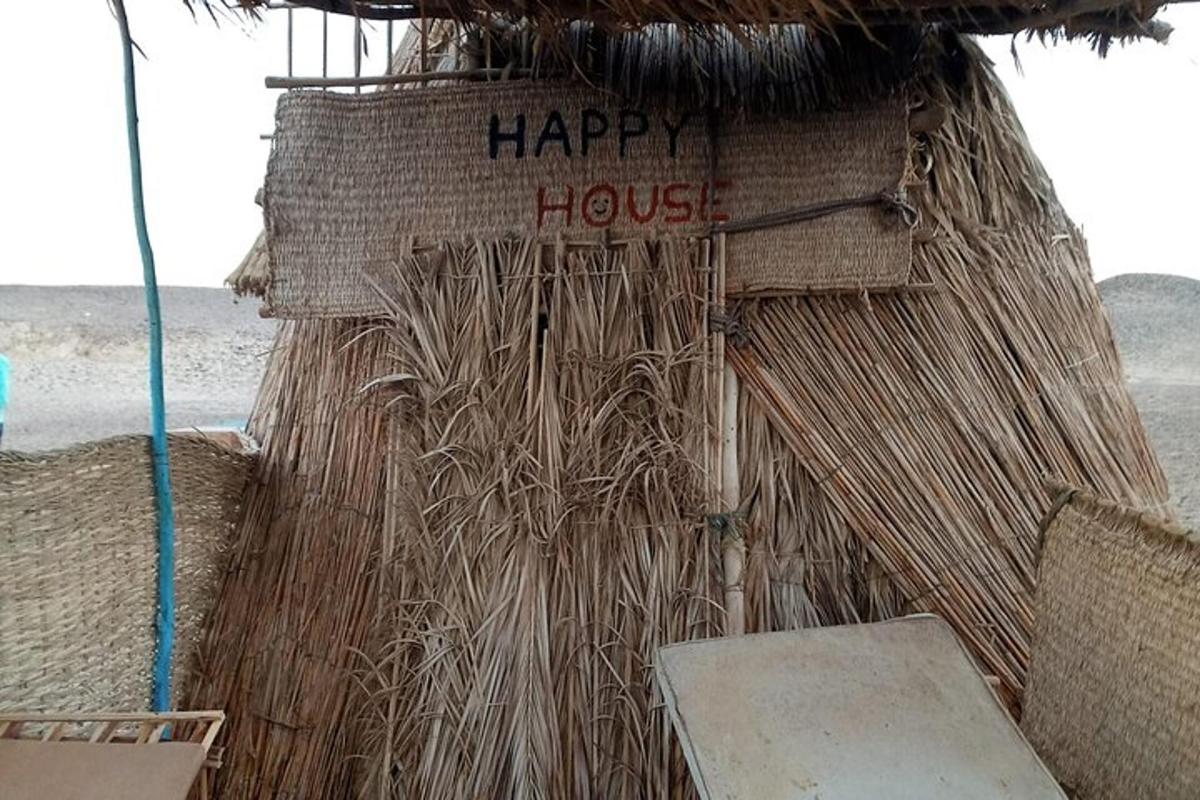 eine Strohhütte mit der Aufschrift „Happy House“