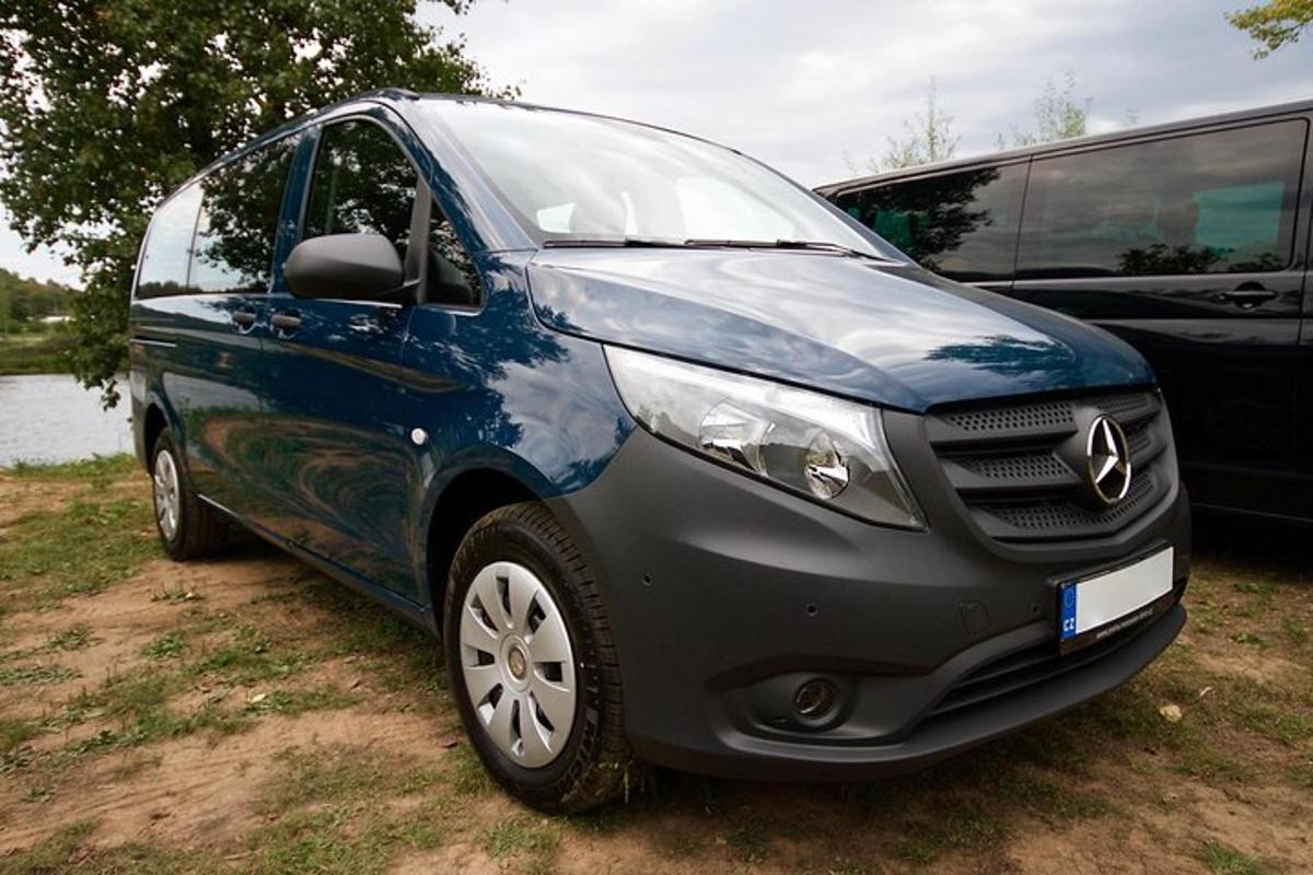un coche azul aparcado junto a un autobús