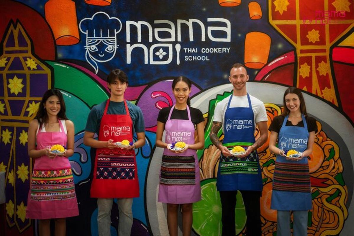 a group of people wearing aprons standing in front of a wall