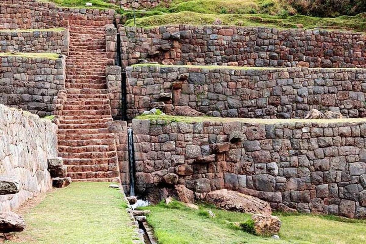 un grande muro di mattoni con l'erba davanti