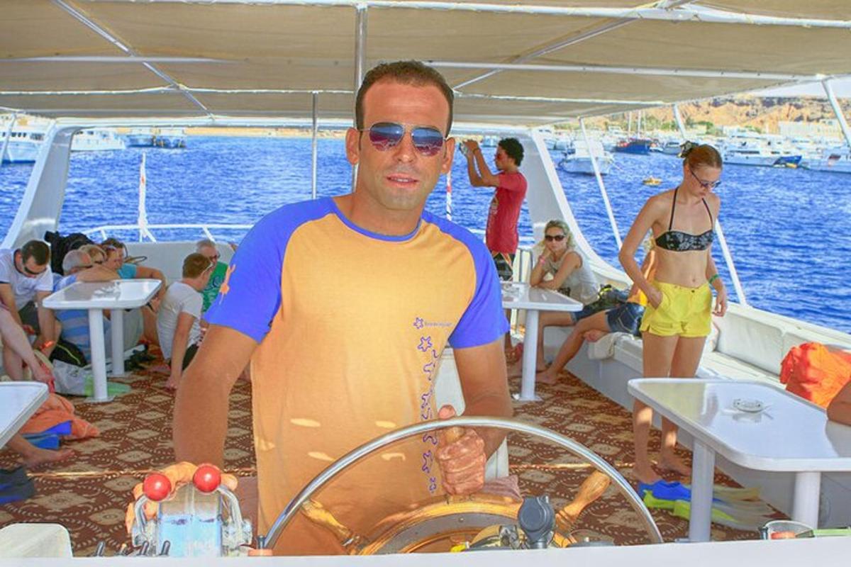 un uomo in piedi al timone di una barca