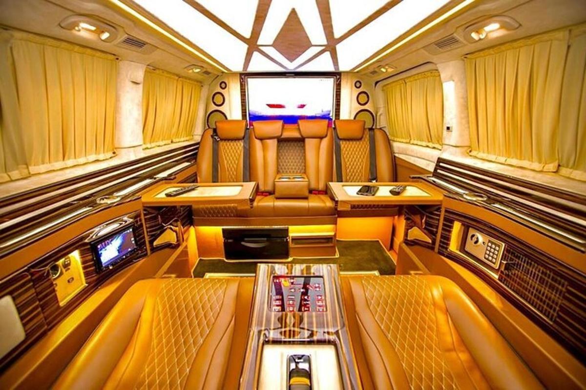 uma sala de trem com assentos laranja e uma tv
