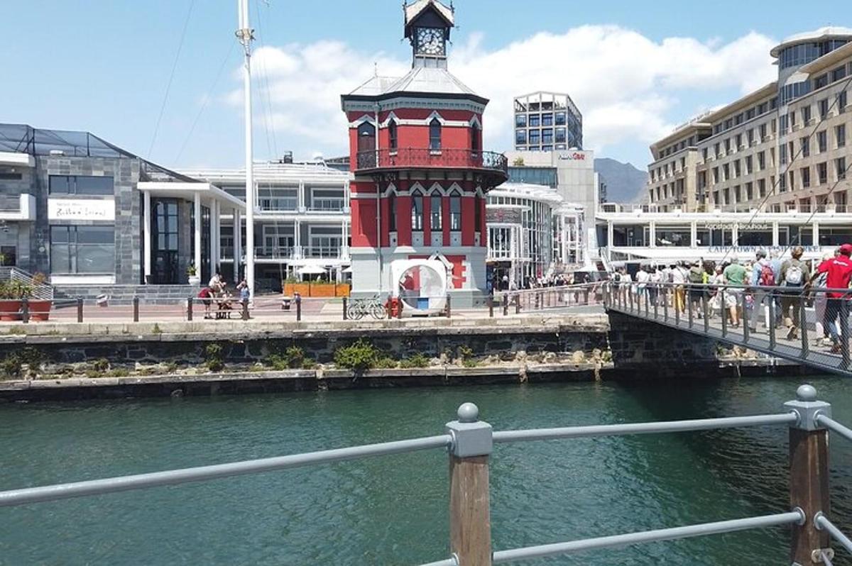 Una torre de reloj roja en un puente sobre un río