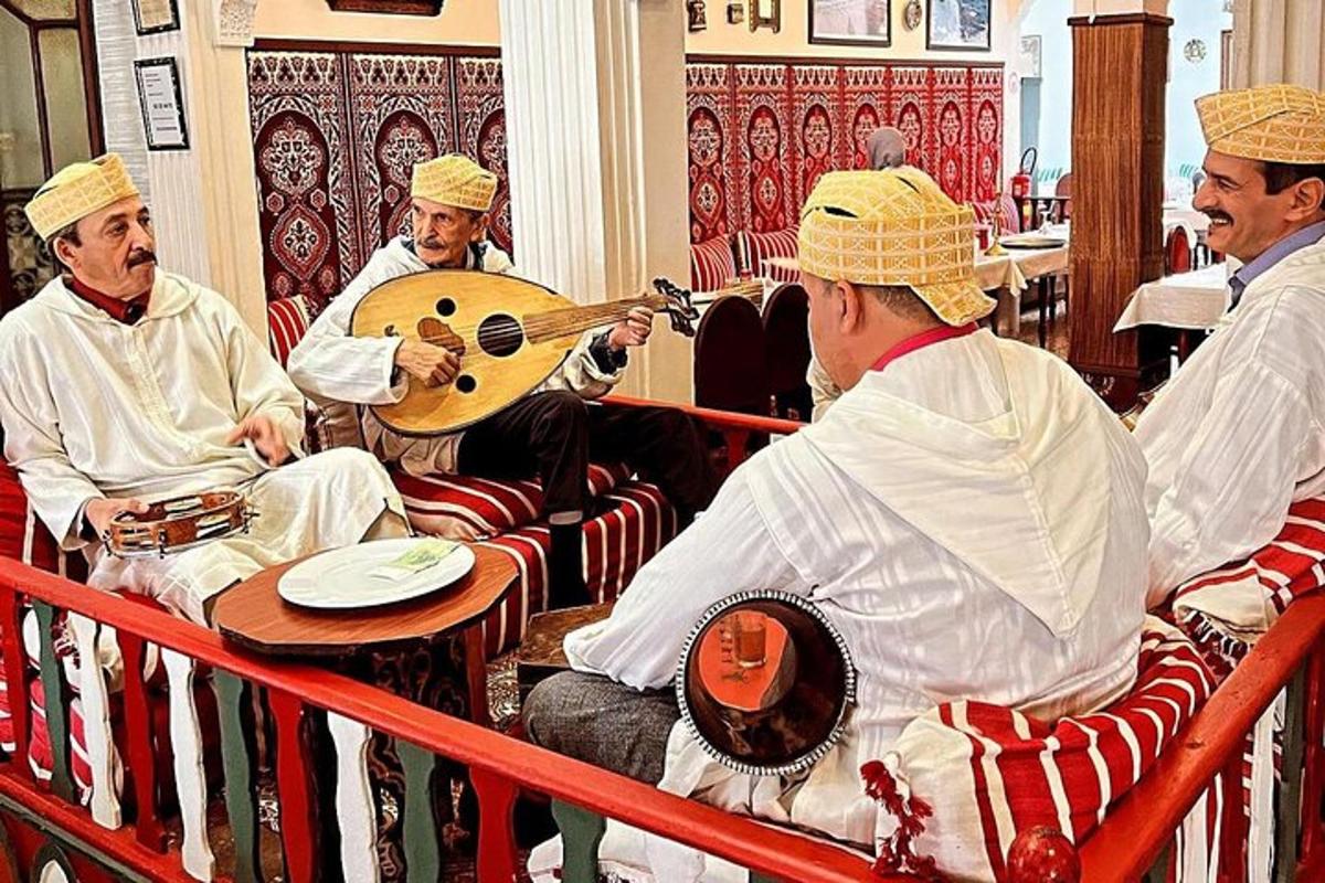 um grupo de homens sentados em uma sala tocando instrumentos