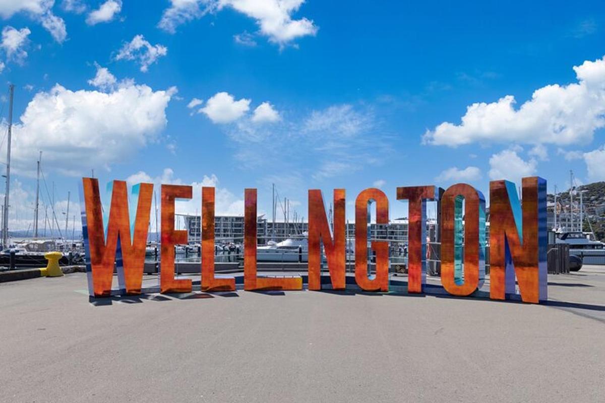 un grande cartello metallico che dice "Benvenuti" in un parcheggio
