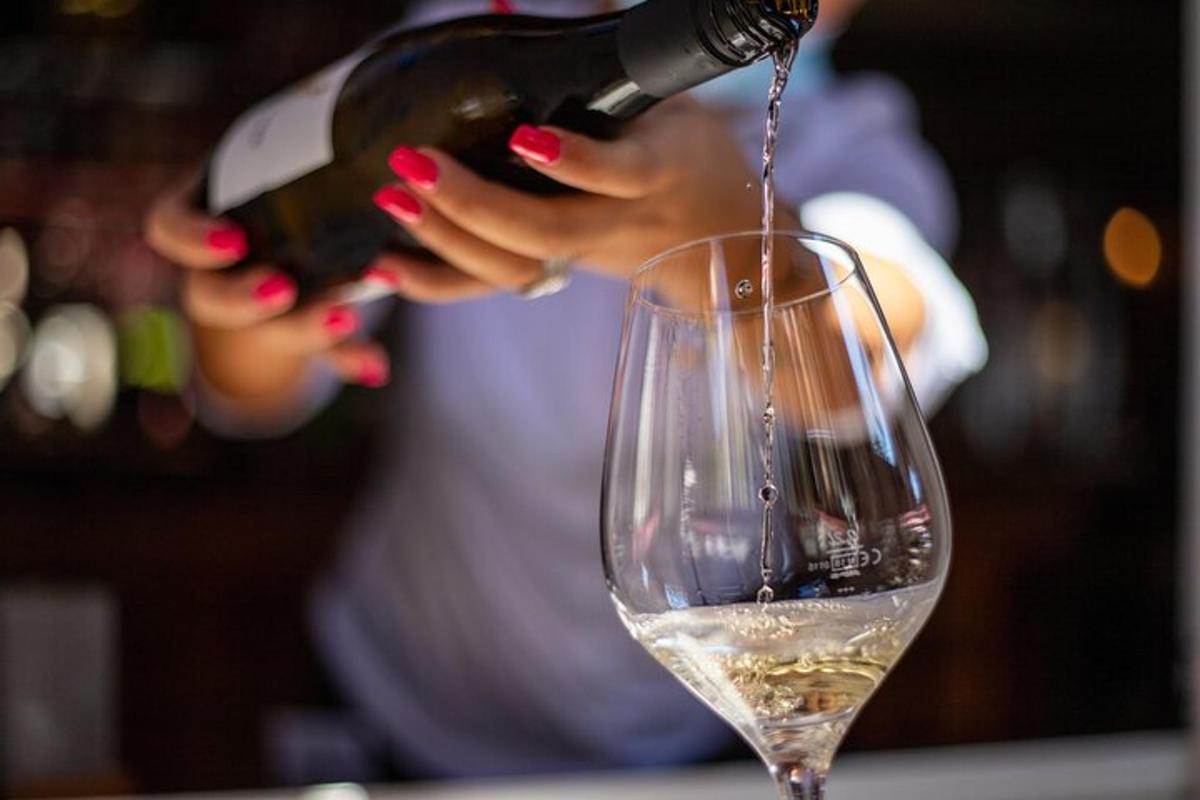 una mujer sirviendo vino en una copa de vino