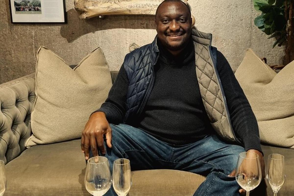 a man sitting on a couch with three wine glasses