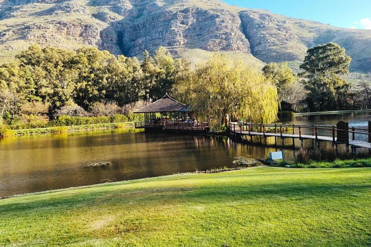 a gazebo next to a river with a mountain