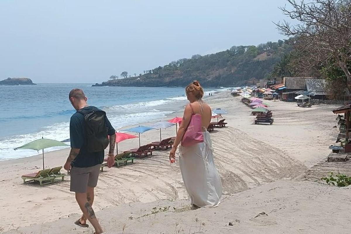 một người đàn ông và một người phụ nữ đang đi bộ trên bãi biển