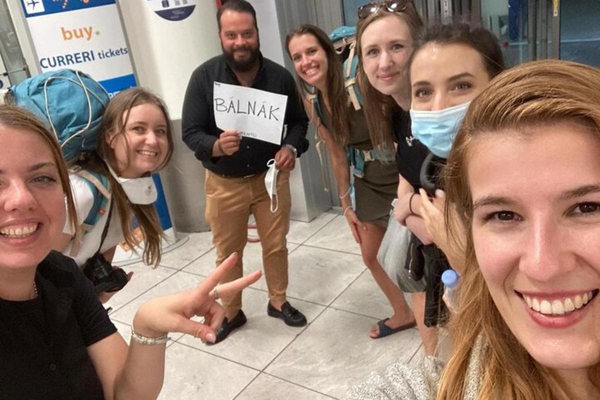 skupina lidí pózujících pro fotografii na letišti