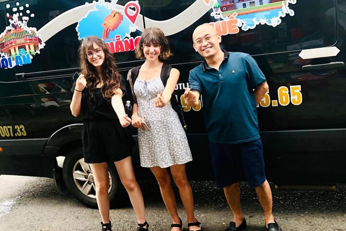 skupina tří lidí stojící před autobusem