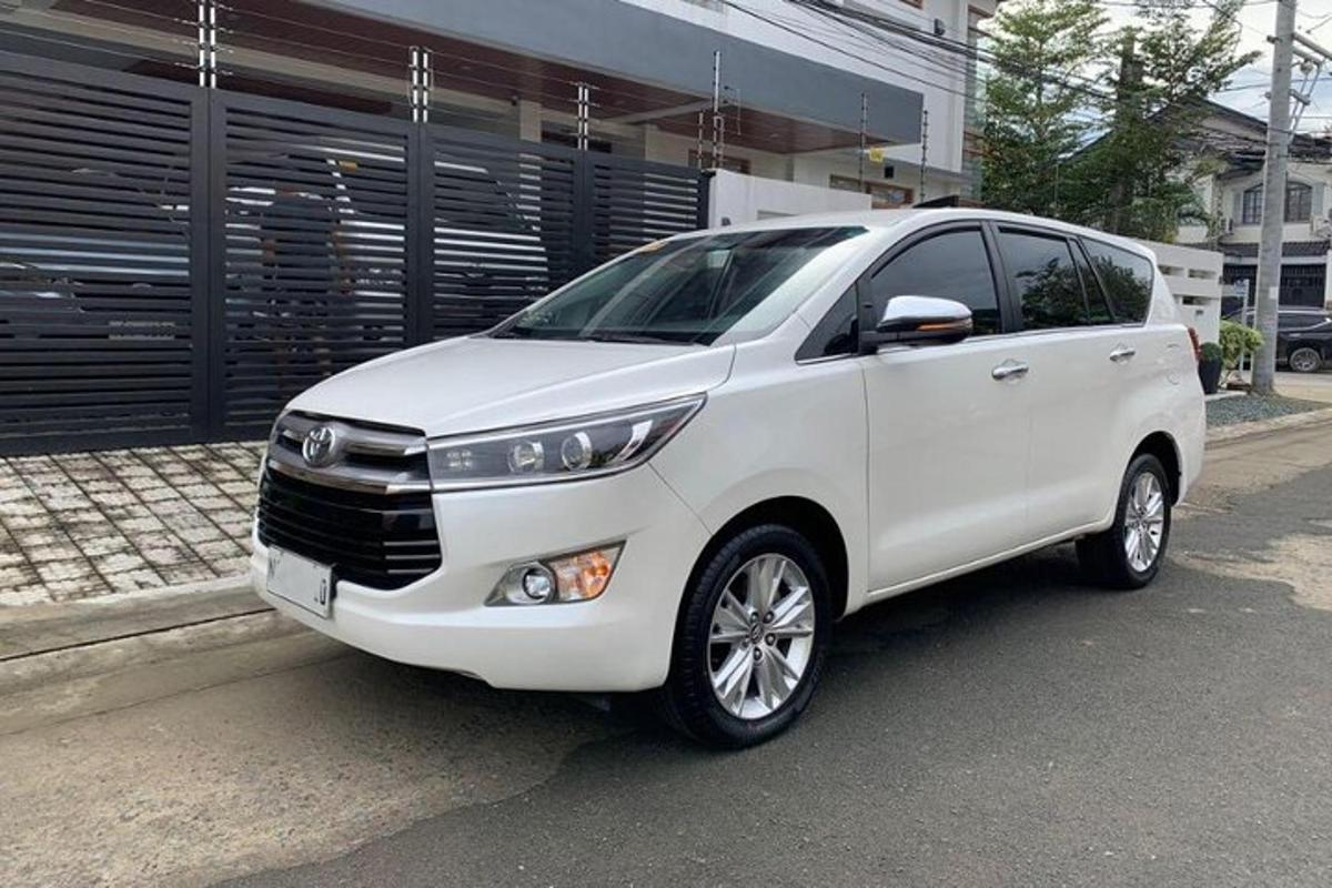 Un coche blanco aparcado delante de un edificio